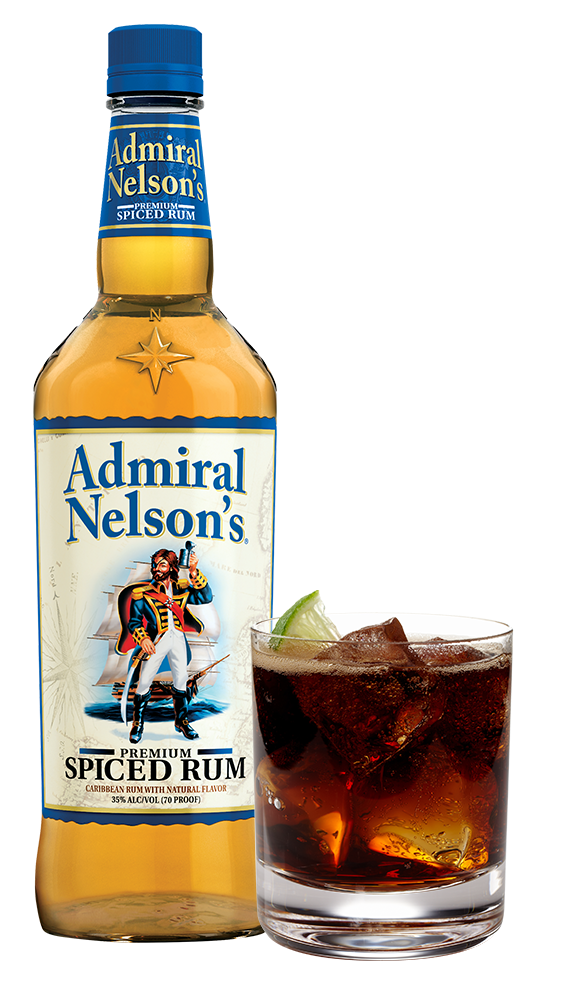 A bottle of rum paired with the glass of brown liquid and sliced lime.